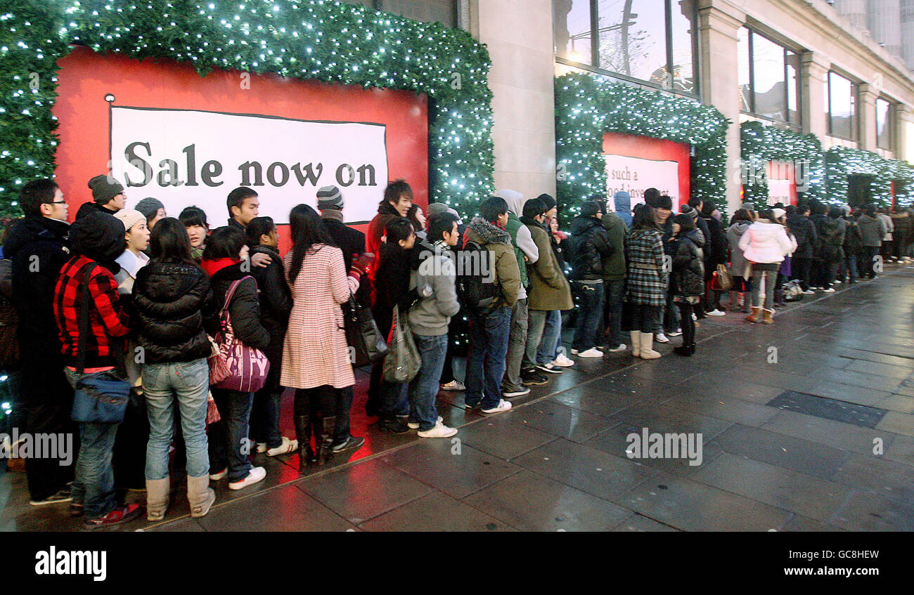 Shoppers queue outside Selfridges on Oxford Street, London, waiting for