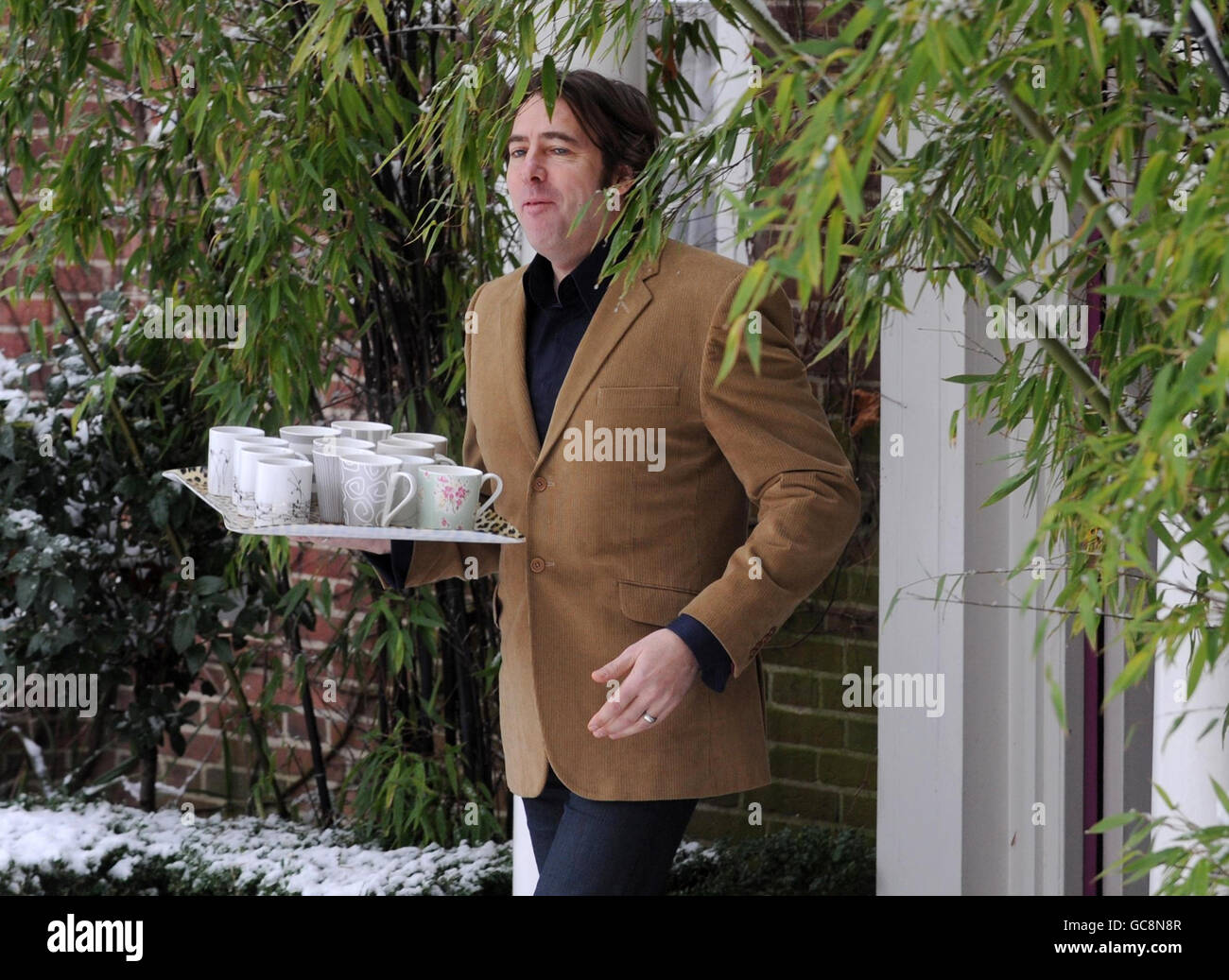 Jonathan Ross brings out cups of tea to the waiting media outside his home in north London, after he announced that he is to quit the BBC. Stock Photo