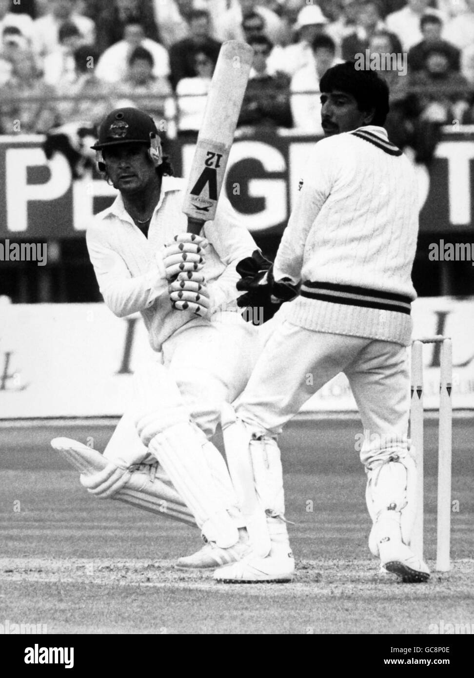 England batsmasn Allan Lamb in action watched by Pakistan wicket-keeper Mansoor Akhtar Stock Photo