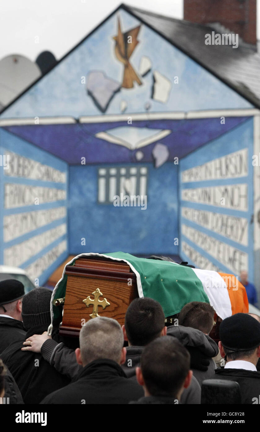 The coffin of Derry dissident republican Jim Gallagher, who was interned in the 1970's, passes a mural depicting the H Blocks in the Bogside area of Belfast, on its way to St Columbas Church for Requiem mass. Stock Photo