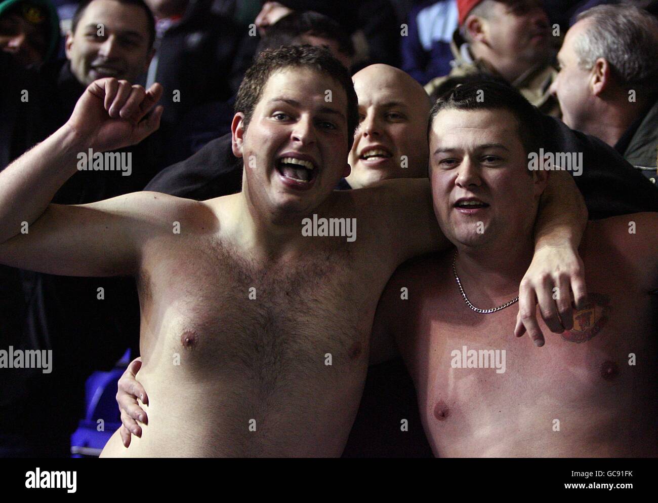 Soccer - Barclays Premier League - Birmingham City v Manchester United - St Andrews Stadium. Despite the freezing conditions Manchester United fans stand up and chant in the stands without any tops on. Stock Photo