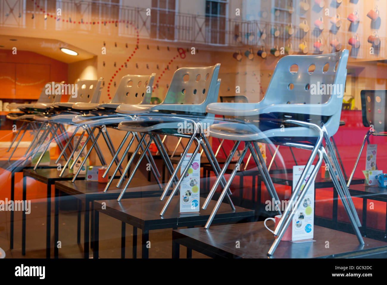 Rows of chairs stacked on tables in a cafe restaurant Stock Photo