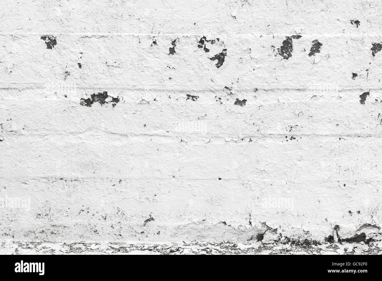 Background texture of white grungy concrete wall with damaged plastering layer Stock Photo