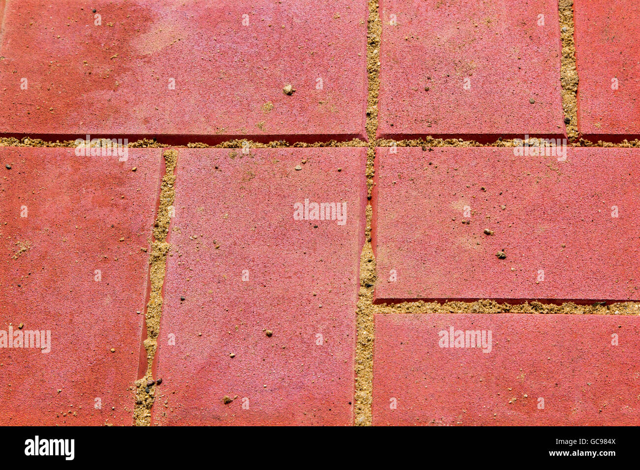 red concrete paving slabs with sand close up Stock Photo
