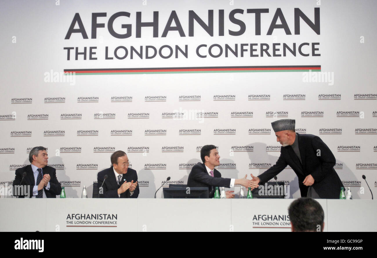 Afghan President Hamid Karzai, right, shakes hands with Britain's Foreign Minister David Miliband, second right, after making a speech as Britain's Prime Minister Gordon Brown, left, and U.N. Secretary-General Ban Ki-moon, second left, applaud him during the Opening Session of the Afghanistan Conference at Lancaster House in London. Stock Photo