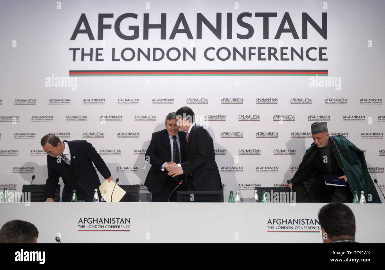 Britain's Prime Minister Gordon Brown (2nd left) shakes hands with his Foreign Secretary David Miliband (2nd right), flanked by U.N. Secretary-General Ban Ki-moon (left) and Afghan President Hamid Karzai (right) as they get up to leave the room after making their speeches in the opening session of the Afghanistan Conference in London. Stock Photo