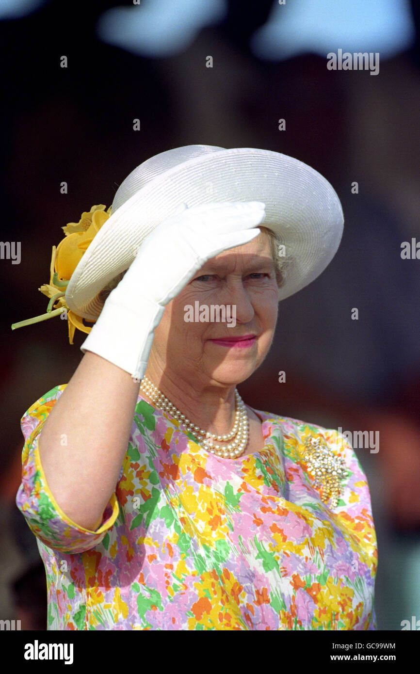 Queen Elizabeth II shades her eyes from the sun at Ronald Webster Park ...