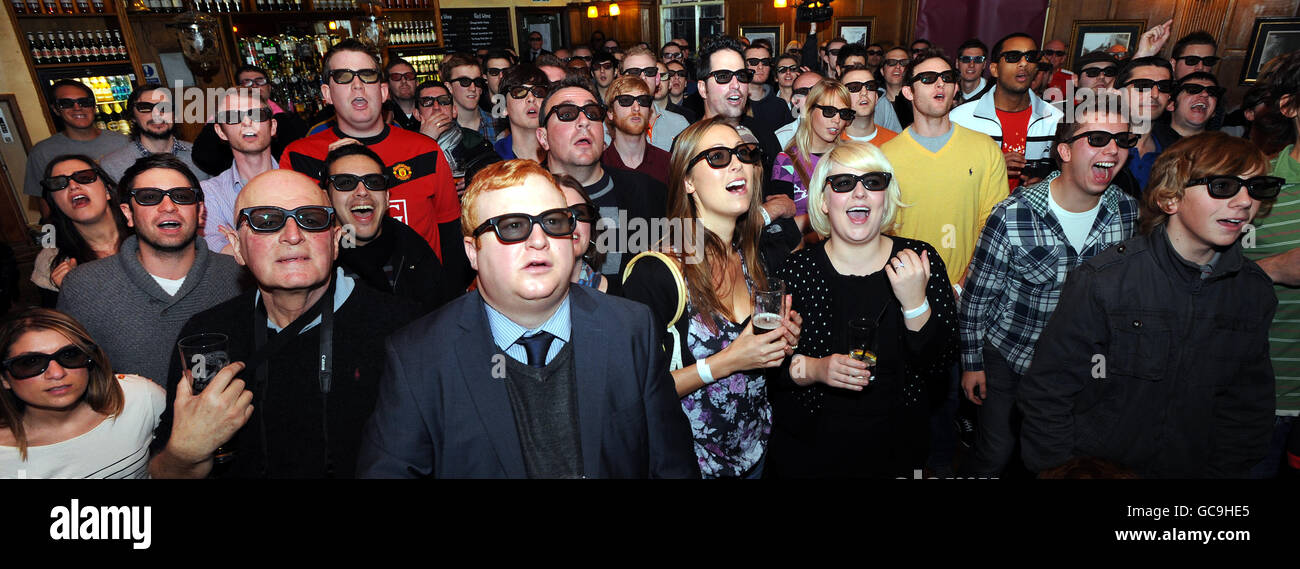 Football fans watch the world's first live 3D TV sports broadcast football match between Arsenal and Manchester Utd in the Railway Tavern in London. Stock Photo