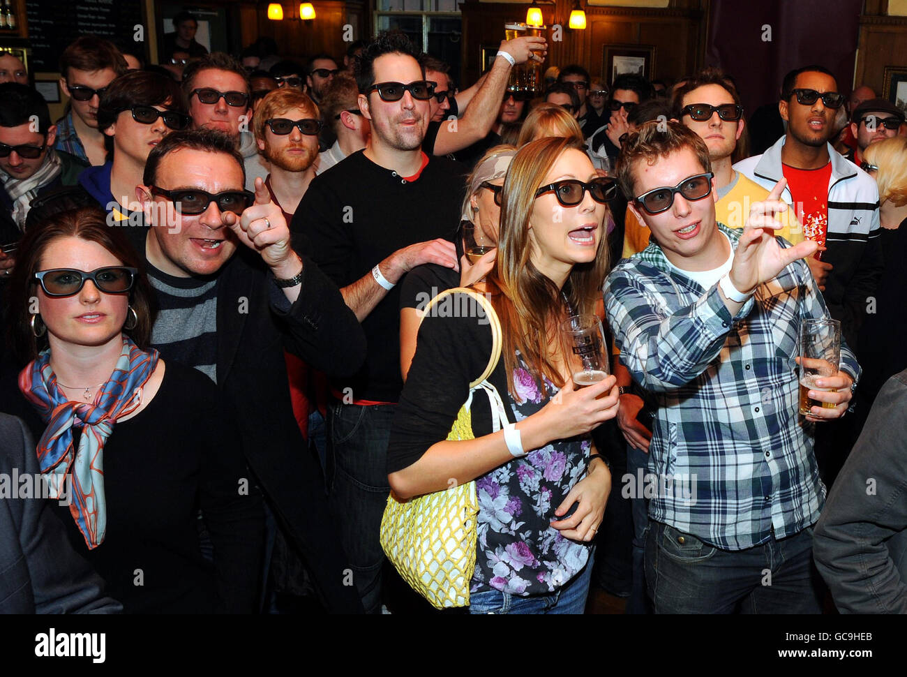 Football fans watch the world's first live 3D TV sports broadcast football match between Arsenal and Manchester Utd in the Railway Tavern in London. Stock Photo
