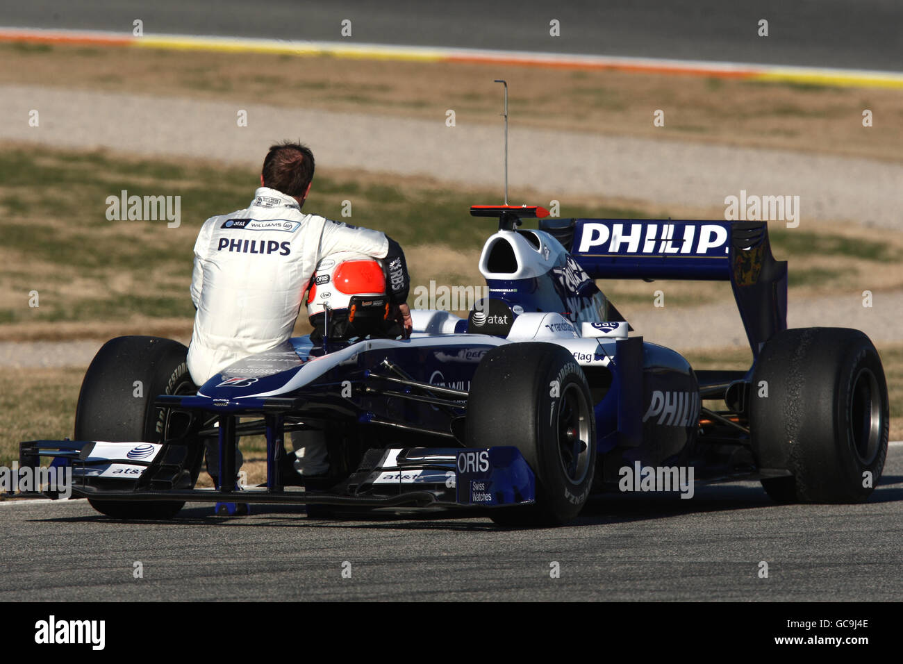 Rubens Barrichello sits on the wing of his new Williams after breaking
