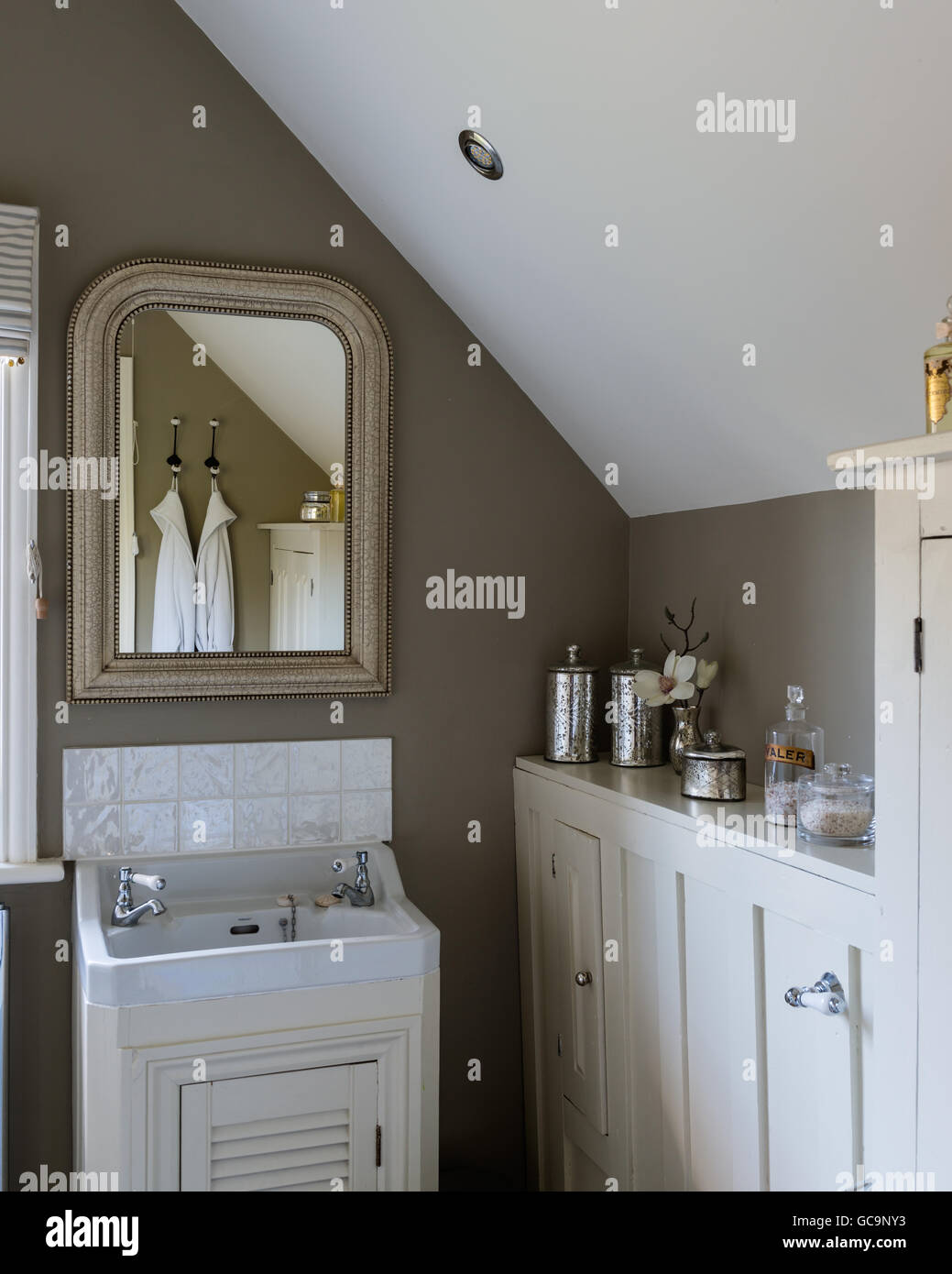 Elegant bathroom with units painted in Clunch and walls in Light Gray both by Farrow & Ball. Stock Photo