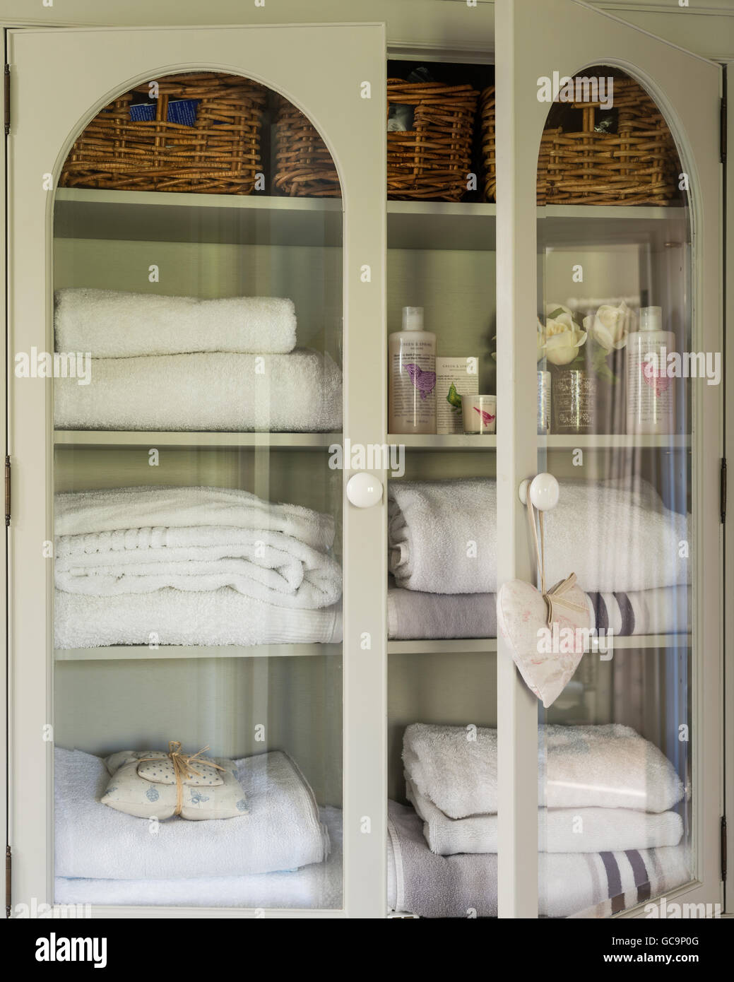 Towels in glass fronted linen cupboard Stock Photo