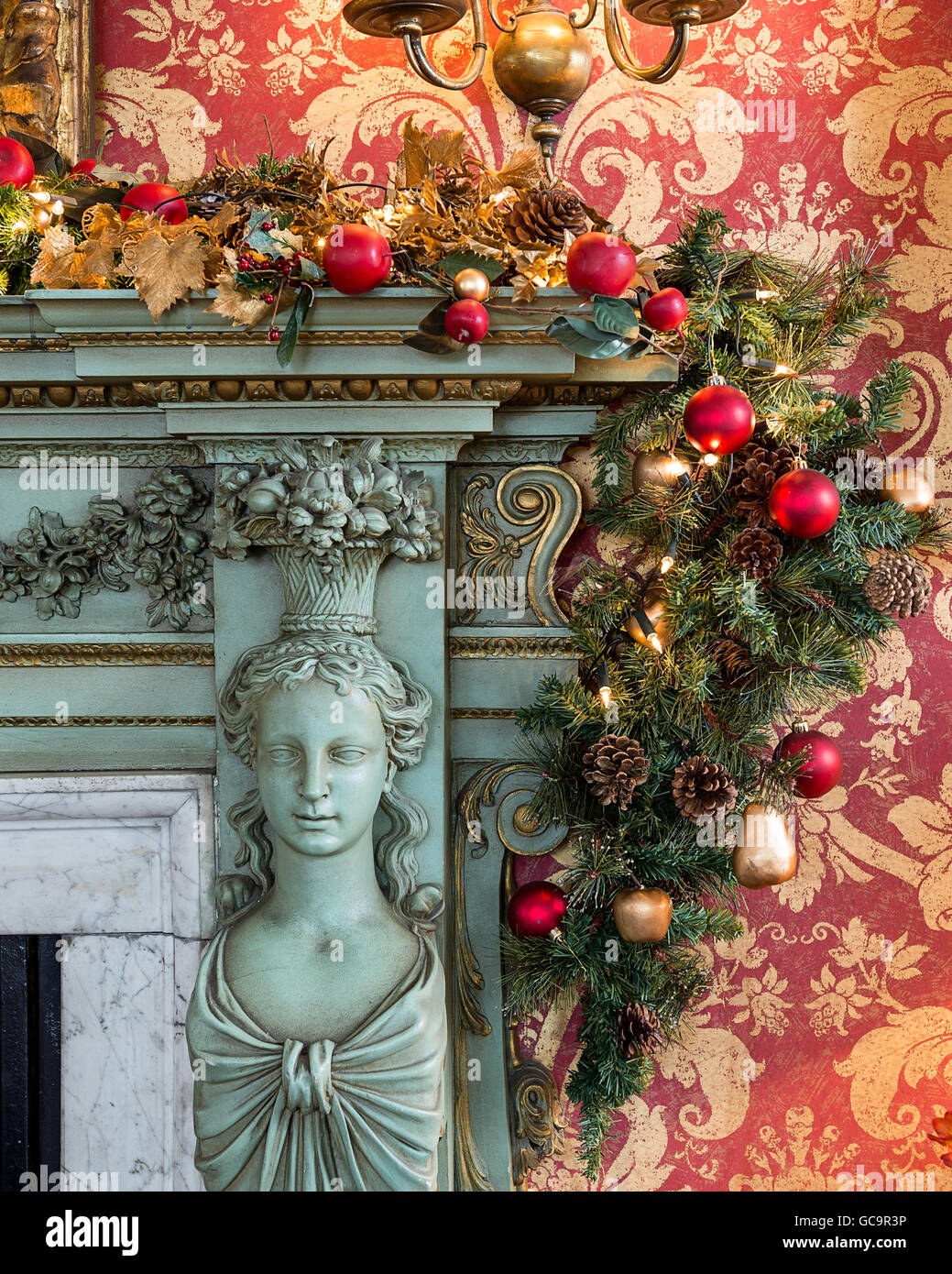 Red and gold damask wallpaper with bauble garland on fireplace in dining room of Grade I listed, Victorian Gothic Carlton Towers Stock Photo