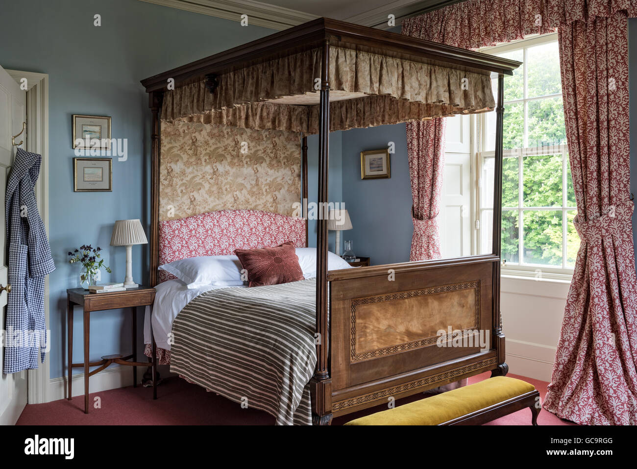 Old four poster bed with original printed cotton hangings. The curtains, cover and bed head are all by Fermoie Stock Photo