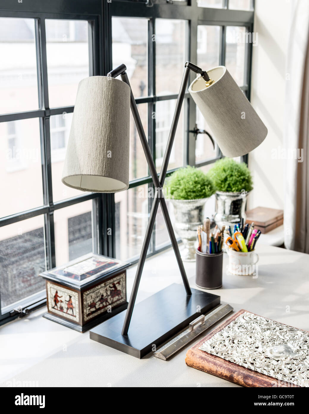 Desk lamp and casket with pencils on desk at window Stock Photo - Alamy