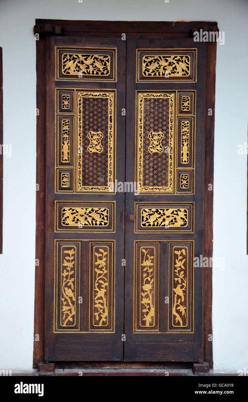 Delicate Peranakan wood carved door with gold inlay in UNESCO World Heritage town of Georgetown Penang Malaysia Stock Photo