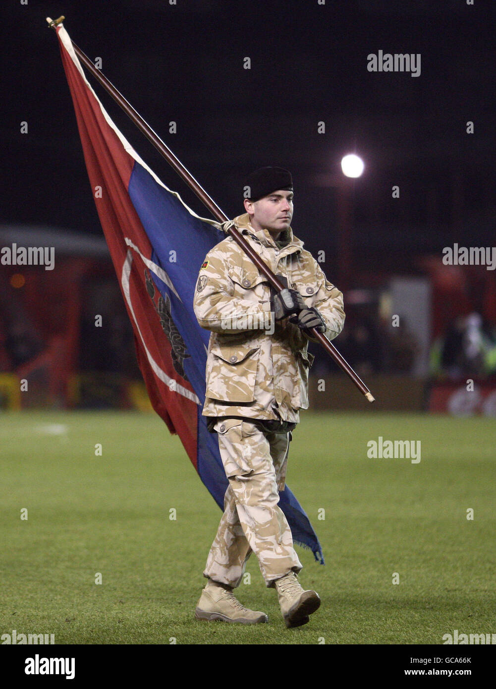 An ISAF soldier from Afaghanistan leads the tems onto the pitch prior to the Coca-Cola Championship match between Bristol City and Cardiff City at Ashton Gate in Bristol. Stock Photo