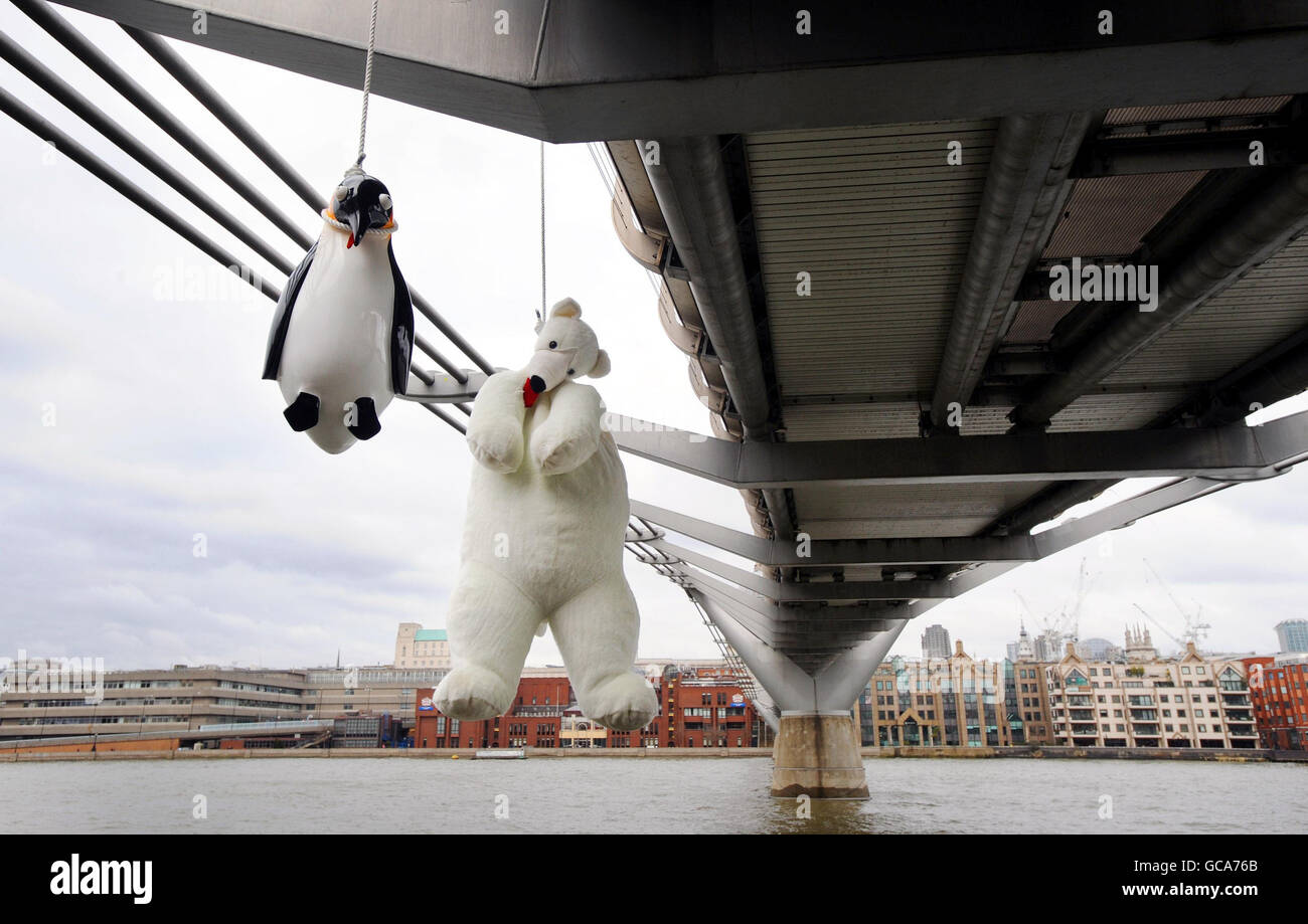 An installation by Taiwanese artist Vincent Huang, entitled 'Suicide Penguins' an installation of penguins and a polar bear, hangs in protest against global warming from the Millennium Bridge, London. Stock Photo