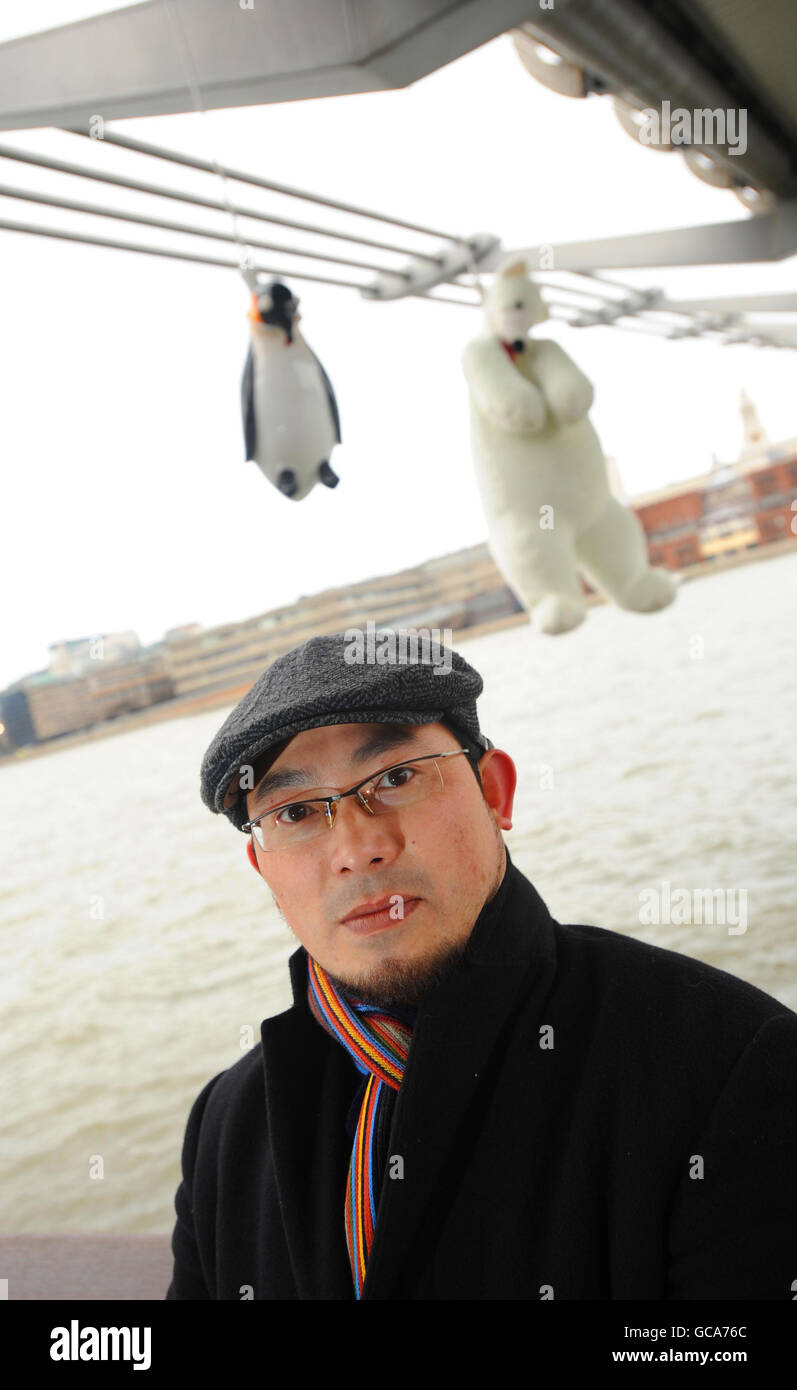 Taiwanese artist Vincent Huang protests against global warming with his 'Suicide Penguins' installation of penguins and a polar bear hanging from the Millennium Bridge, London. Stock Photo