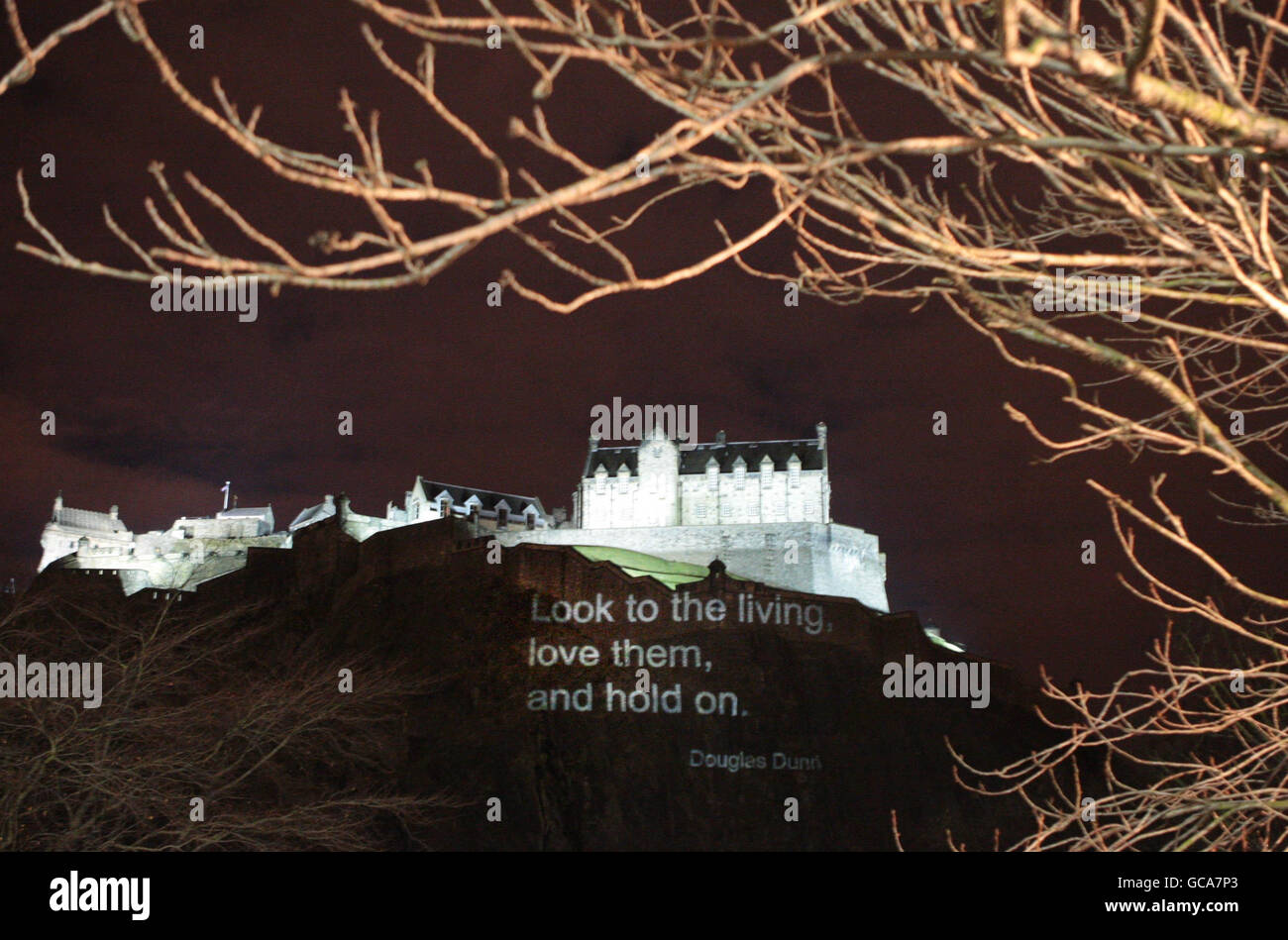 A line of poetry from 'Disenchantments' by the award-winning Scottish poet Douglas Dunn is projected onto Edinburgh castle. Stock Photo