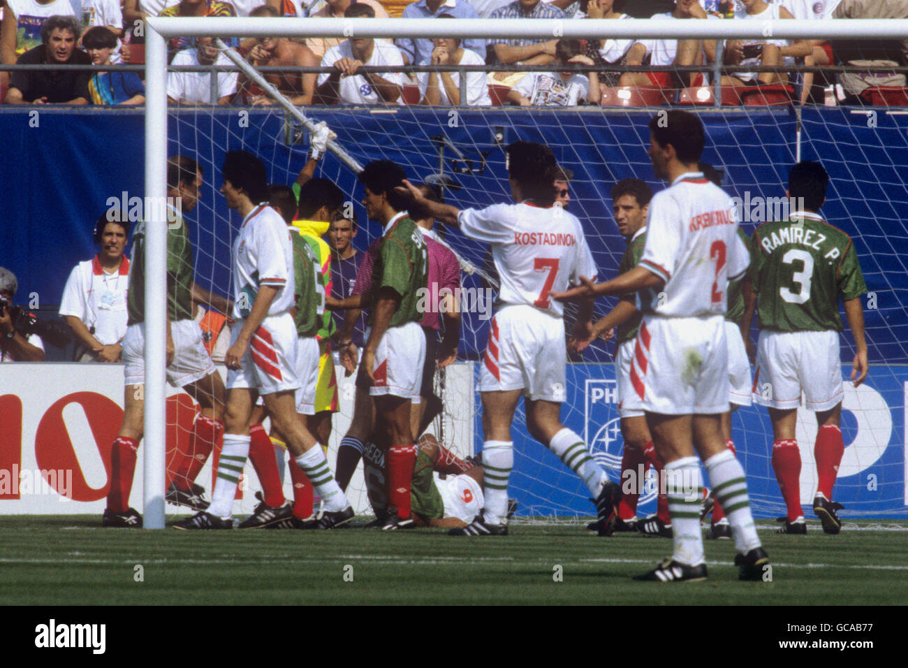 Mexico's Marcelino Bernal (on floor) tries to unravel himself from the goal net after falling into the goal. Mexico Goalkeeper Jorge Campos (hidden) pulls on the broken stanchion. Stock Photo