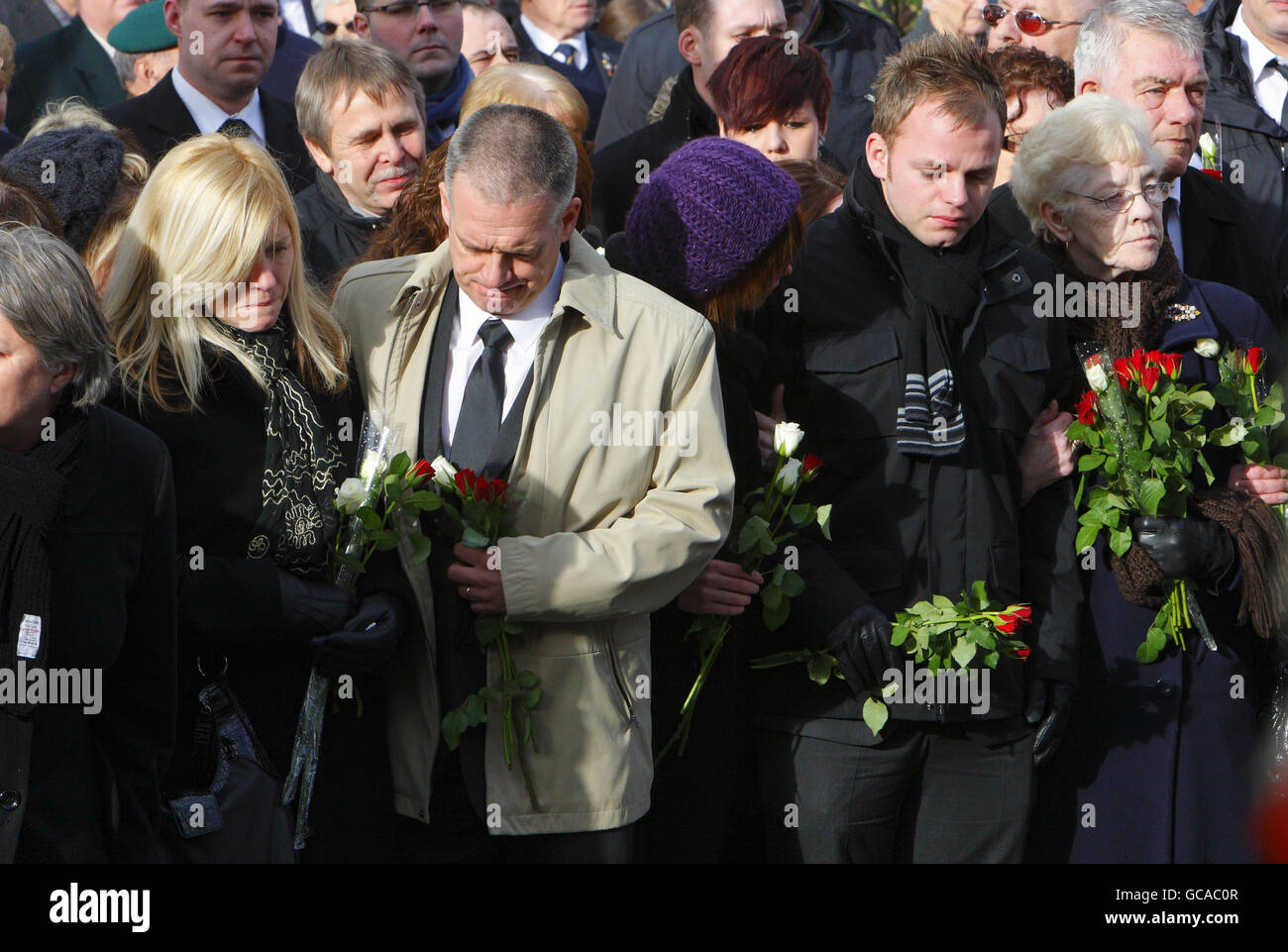 Cheryl Routledge (left), mother of Corporal Liam Riley of 3rd Battalion The Yorkshire Regiment, with her partner Trevor Routledge (beige coat) and other son Jonathan (right) as her son's coffin passes through Wootton Bassett in Wiltshire after being repatriated from Afghanistan. Stock Photo