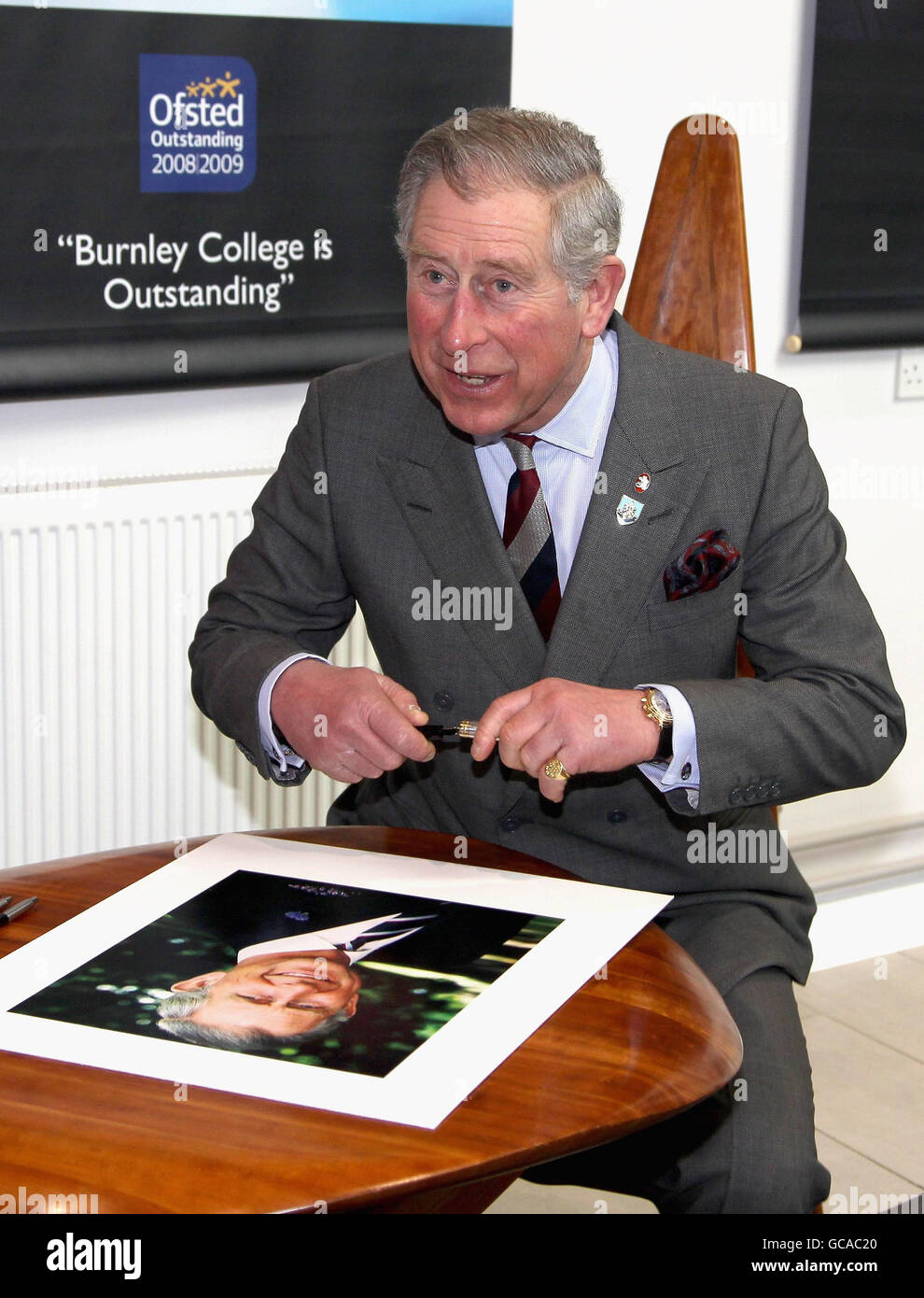 The Prince of Wales signs a portrait as he visits Burnley College / University of Central Lancashire Campus in Burnley, Lancashire. Stock Photo
