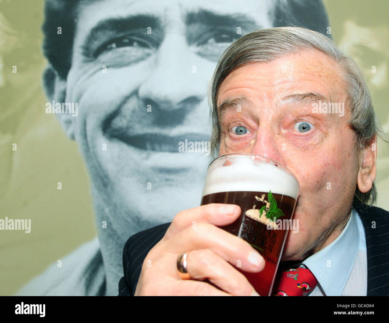 Former International cricket umpire Dickie Bird raises his glass of the