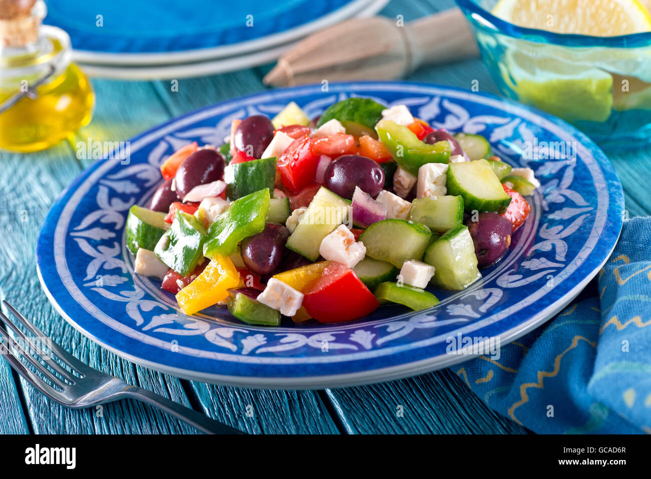 A delicious greek salad with feta cheese, kalamata olives, cucumber, peppers, onion, and tomato. Stock Photo