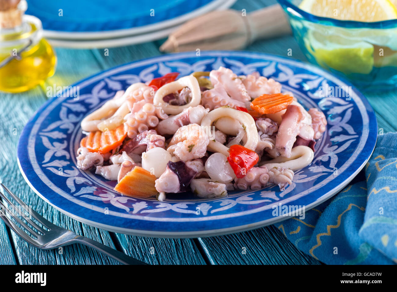 A delicious mixed seafood salad with octopus, calamari, shrimp, onions, red pepper, and carrot. Stock Photo
