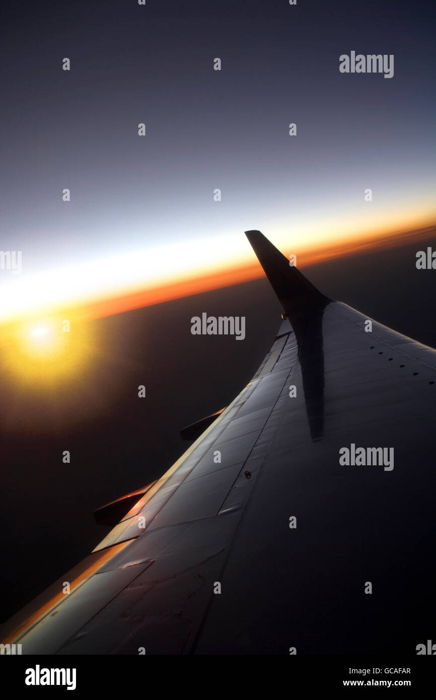 BOEING 737 700 WING SUNSET GLOW OVER HORIZON Stock Photo
