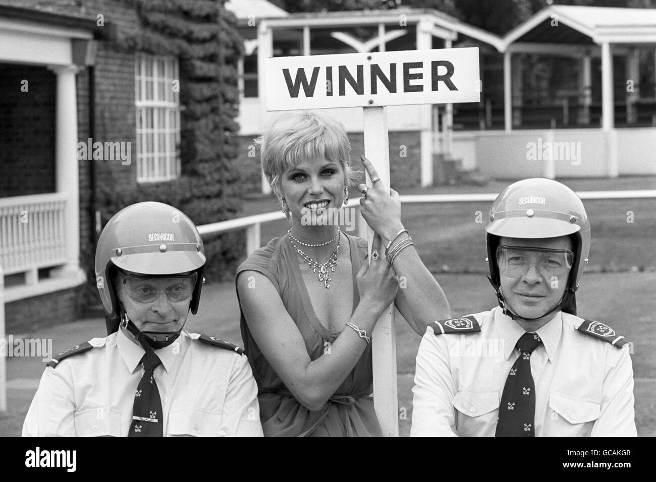 British actress and model Joanna Lumley (of the 'New Avengers' TV series) shows off some of the jewelry from the famous House of Cartier, while two of Cartier's guards protect her. Stock Photo