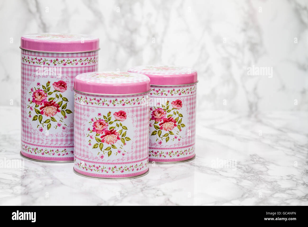 Decorative tin boxes with floral pattern on white marble background Stock Photo