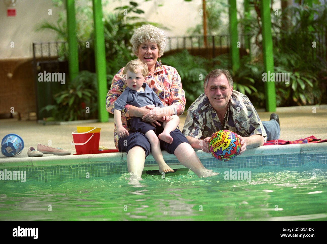 JACK & VERA DUCKWORTH (BILL TARMEY & ELIZABETH DAWN) WITH THEIR GRANDSON TOMMY (DARYL EDWARDS), HAVE A DIP IN THE POOL AT TALACRE CARAVAN PARK, NORTH WALES, DURING FILMING FOR ITV. Stock Photo