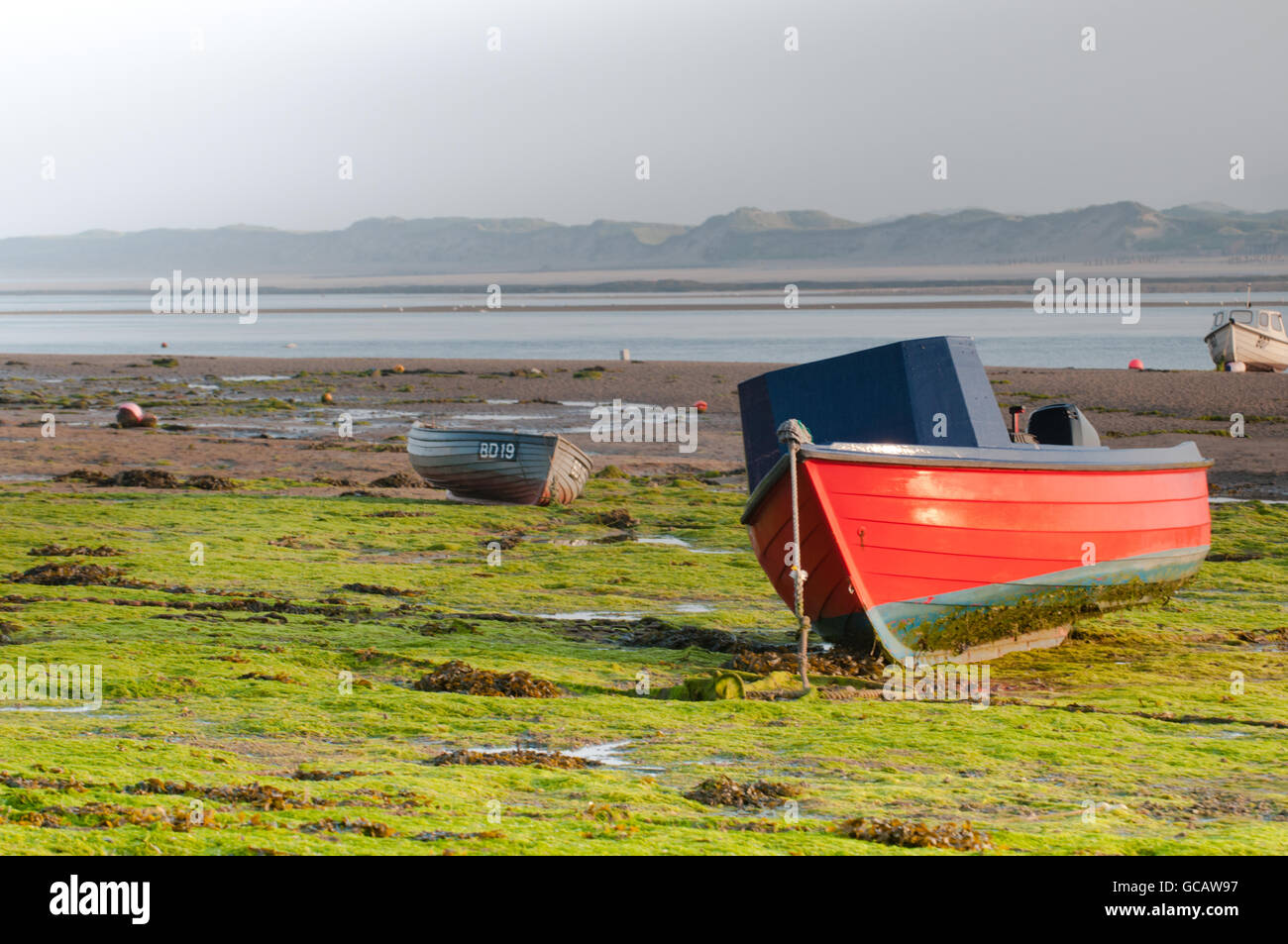 Fishing boat at sunrise at low tide in the estuary Stock Photo - Alamy