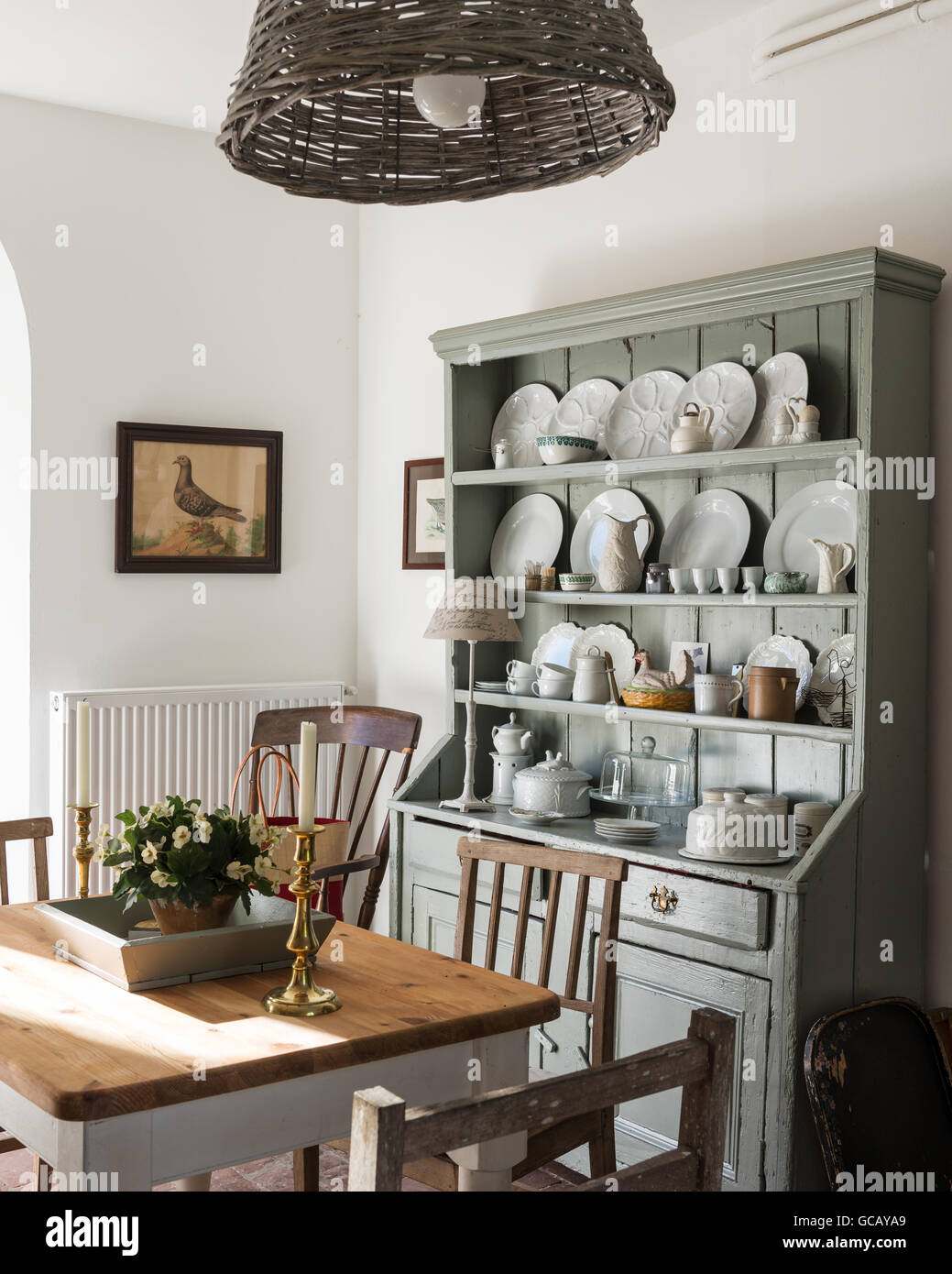 Irish open shelf dresser in dining area with basket lampshade by Leroy Merlin Stock Photo