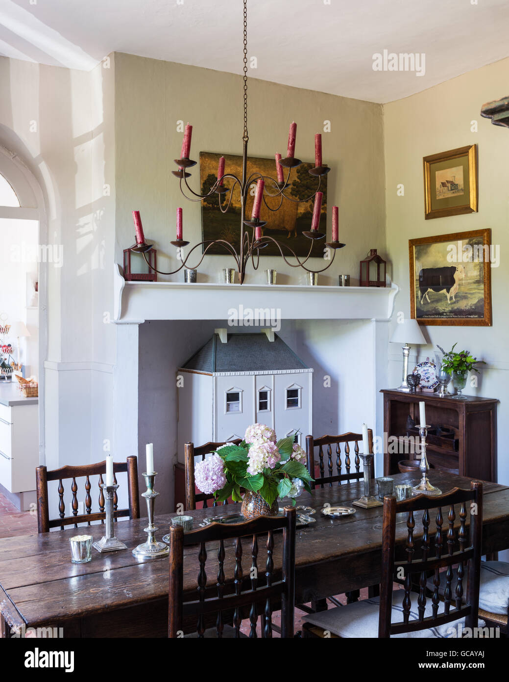 18th century oak table and Yorkshire chairs in dining room with terracotta flooring and ceiling candelabra Stock Photo