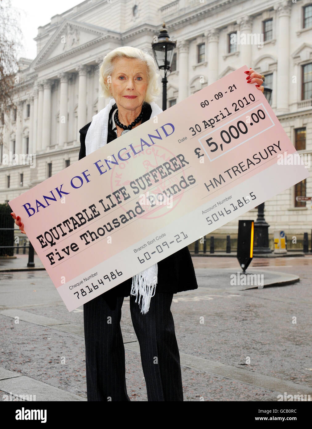Honor Blackman holds a giant fake cheque near the Treasury, London. The actress is supporting the Equitable Members Action Group who are today holding news conference as part of their campaign urging the Government to help those who lost up to 50 per cent of their pensions with the near collapse of Equitable Life. Stock Photo