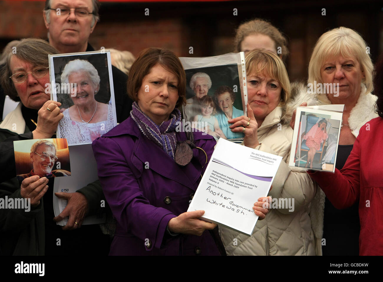 Relatives of patients involved in the report hold pictures of their loved ones outside the Moat House hotel near Stafford, after Robert Francis QC delivered his report into failings at Stafford Hospital. Stock Photo
