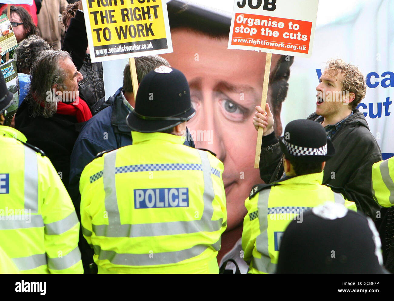 Demonstrators protest against Conservative Party politics at the front door to the Conservative Party Spring Forum in Brighton, East Sussex. Stock Photo