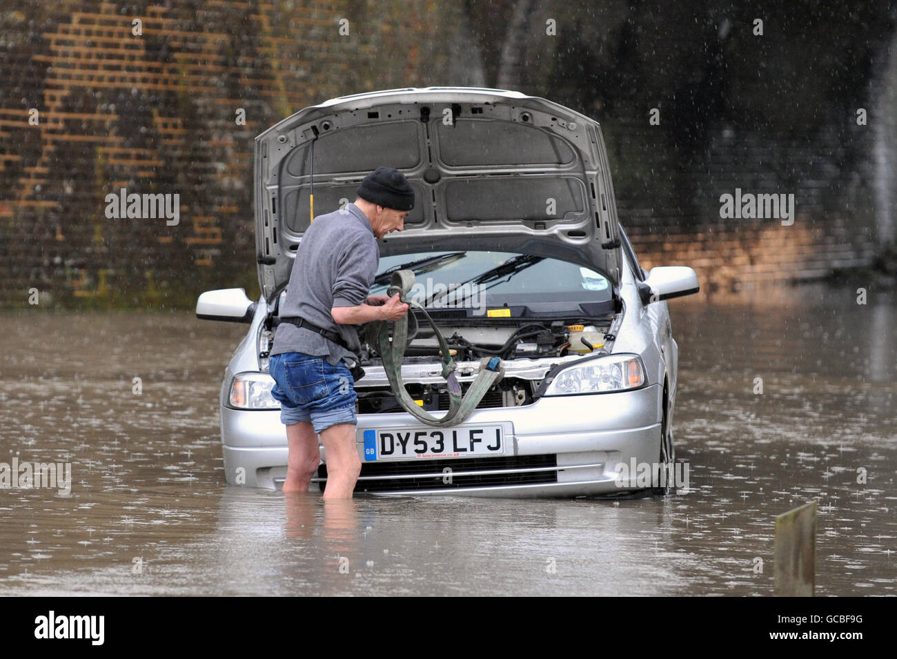 A driver is towed out of deep water by police after getting stuck on a flooded road in Essex. Stock Photo