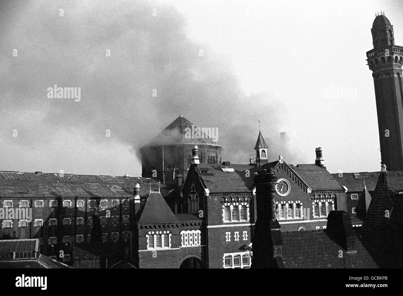 Smoke billows from the roof of Strangeways Prison in Manchester after inmates apparently set fire to debris piled inside. Stock Photo