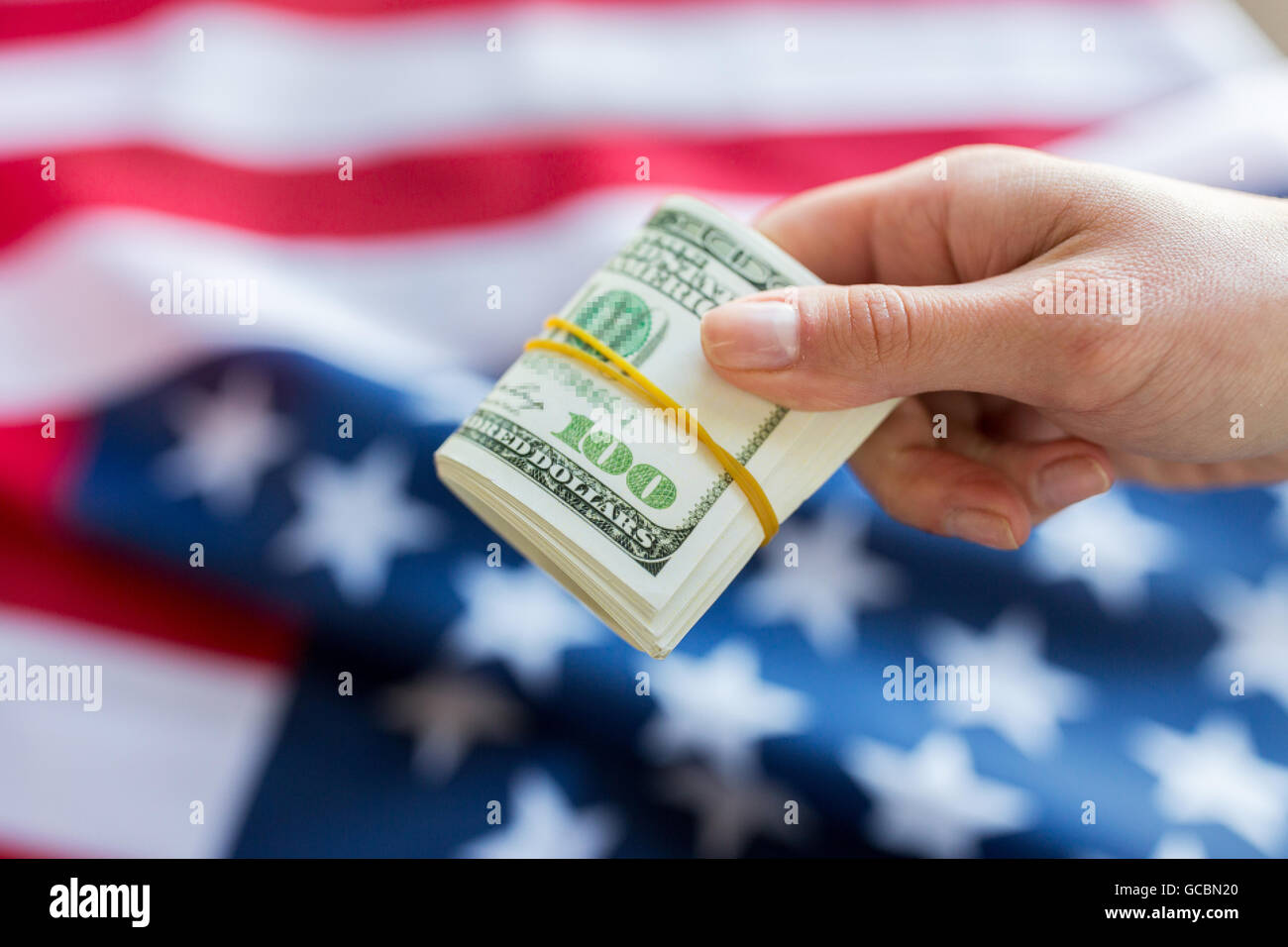 close up of hand with money over american flag Stock Photo