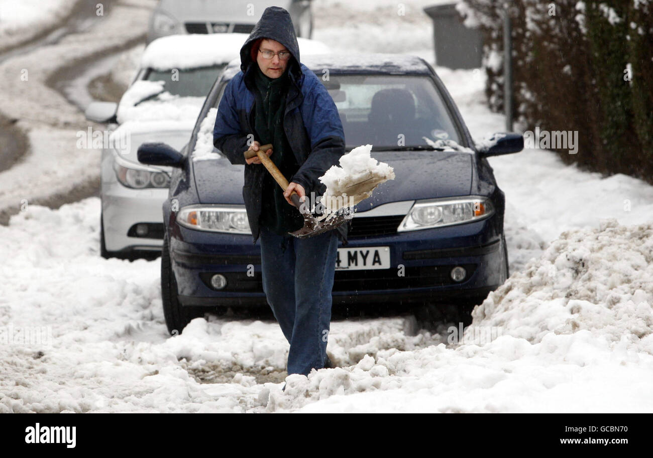 A man shovels snow in Newton Mearns after heavy snow falls across Scotland overnight. Stock Photo