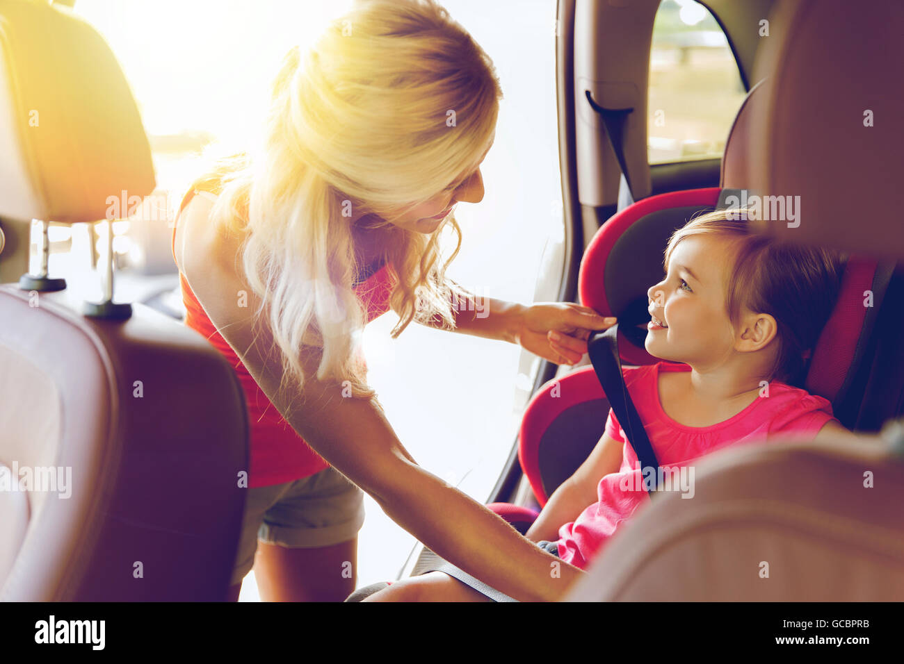 happy mother fastening child with car seat belt Stock Photo