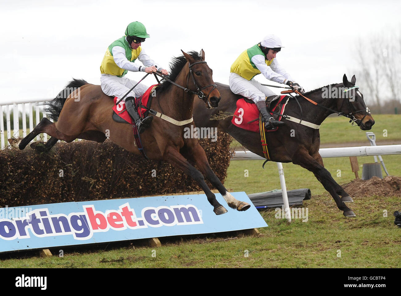 Cloudy Lane ridden by Brian Harding (right) with Coe ridden by Richard McGrath both in the colours of owner Trevor Hemmings jump the final fence in the sportingbet.com Grimethorpe Chase at Doncaster Racecourse, Doncaster. Stock Photo