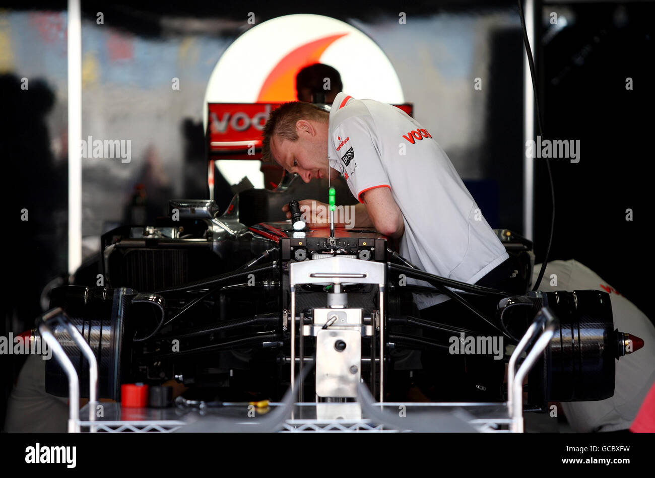McLaren mechanics make last minute checks to lewis Hamilton's car in the garage prior to the Gulf Air Bahrain Grand Prix at the Bahrain International Circuit in Sakhir, Bahrain. Stock Photo