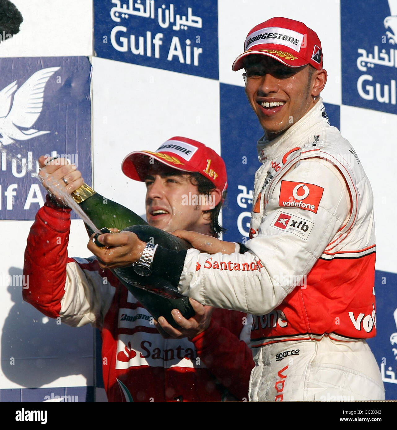 McLaren's Lewis Hamilton (right) celebrates his third place with winner Fernando Alonso during the Gulf Air Bahrain Grand Prix at the Bahrain International Circuit in Sakhir, Bahrain. Stock Photo
