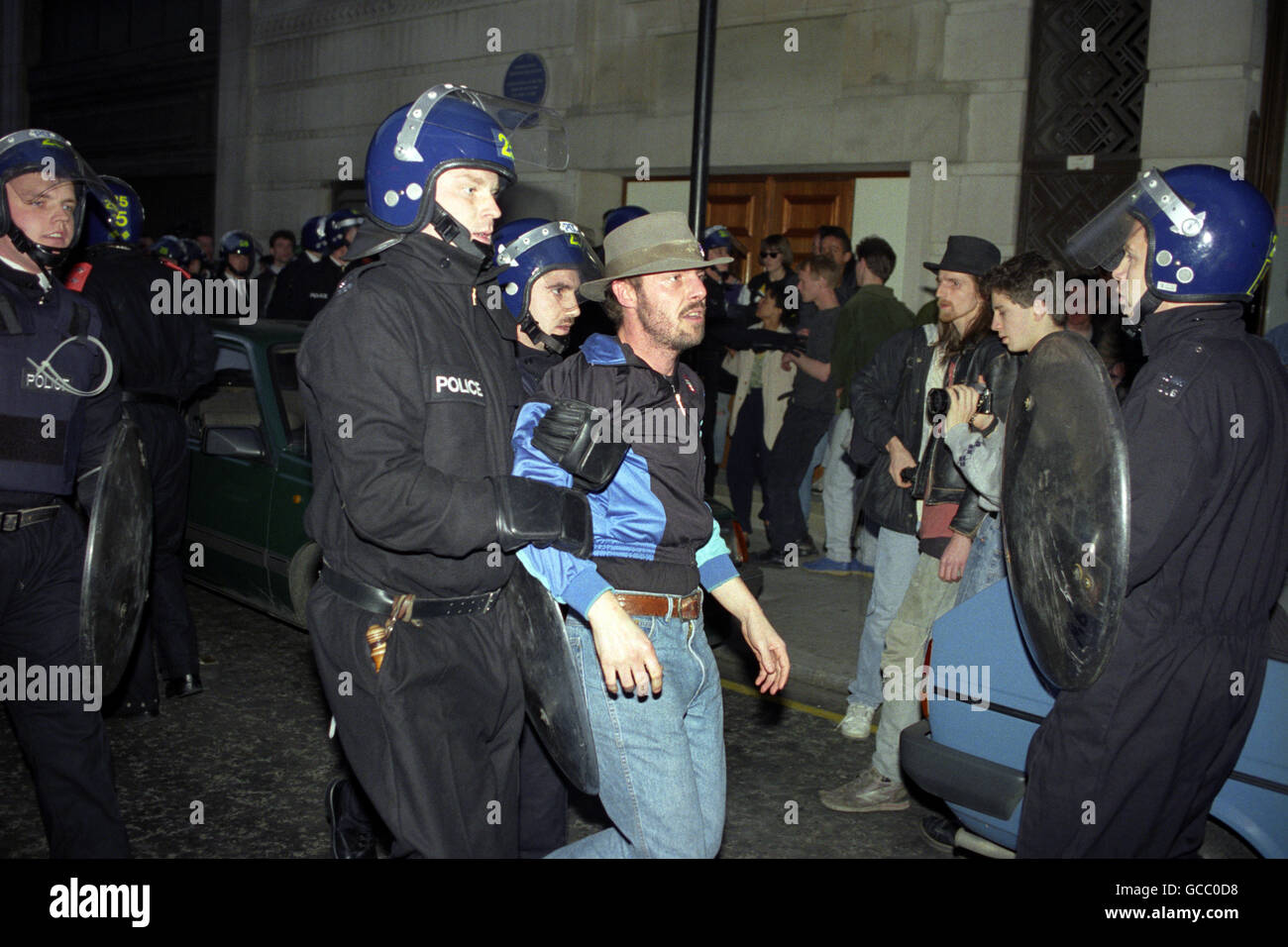 Riot police arrest a man during the riots in central London. The Anti-Poll Tax protests in central London would turn into some of the worst rioting seen in the capital for many years. Stock Photo