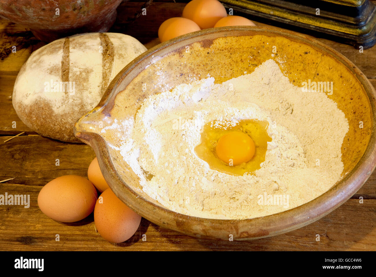 https://c8.alamy.com/comp/GCC4W6/flour-and-egg-yolk-in-an-antique-bowl-ready-to-make-bread-dough-GCC4W6.jpg